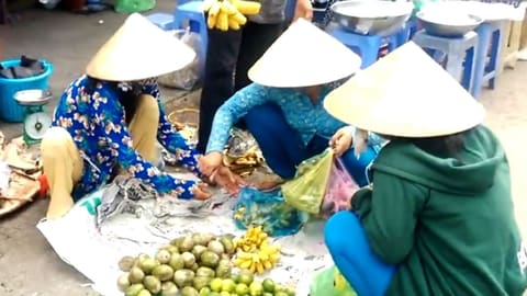 Tiểu thương đội nón lá bán nông sản ở chợ
